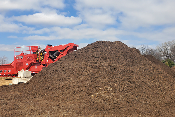 pile of wood mulch with mulch machine